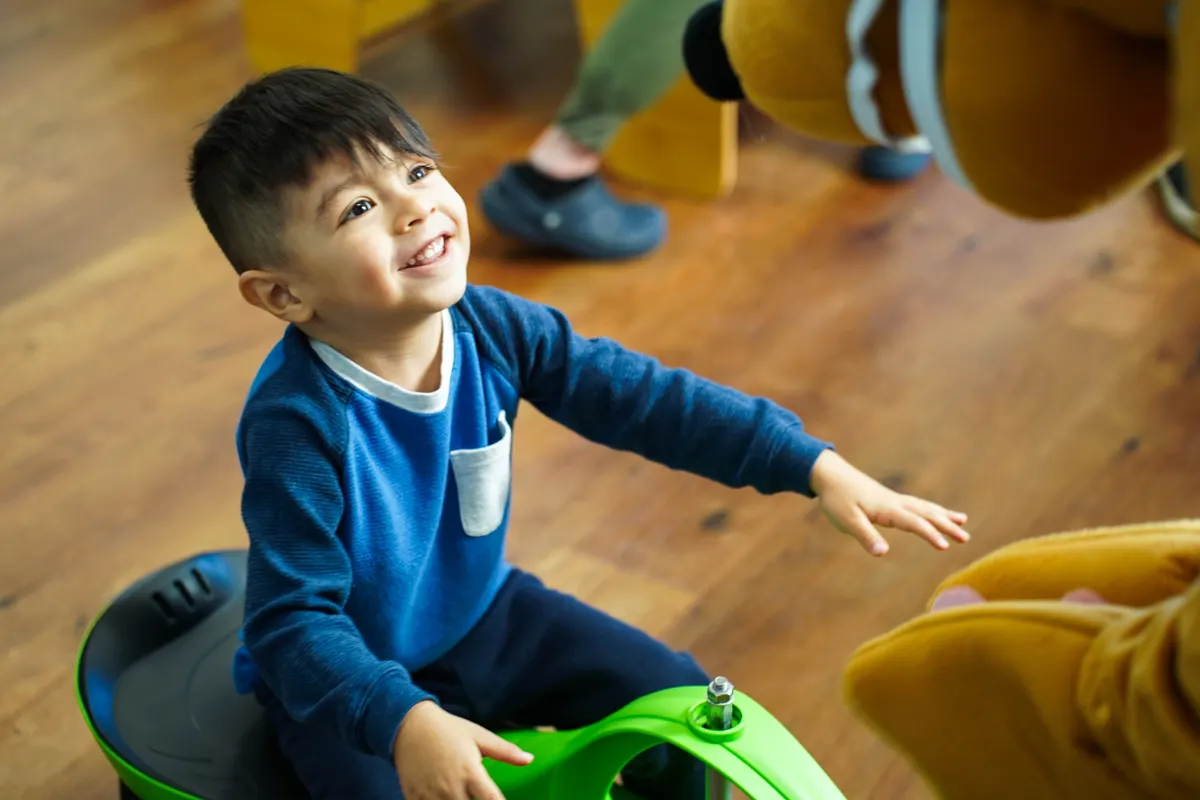 A child smiling joyfully during a therapy session at a Behavioral Innovations center