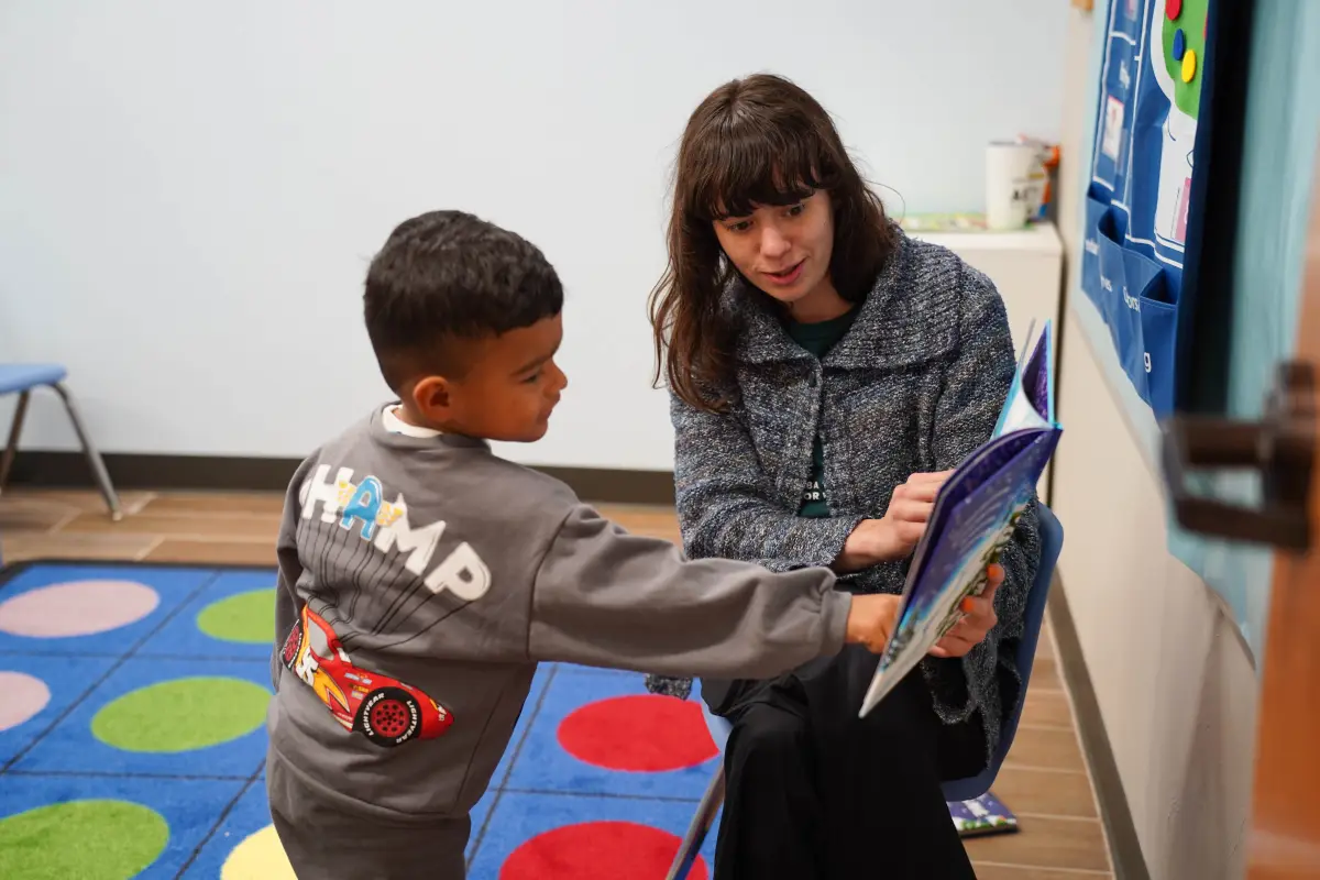 BCBA therapist reading with a child in a therapy room