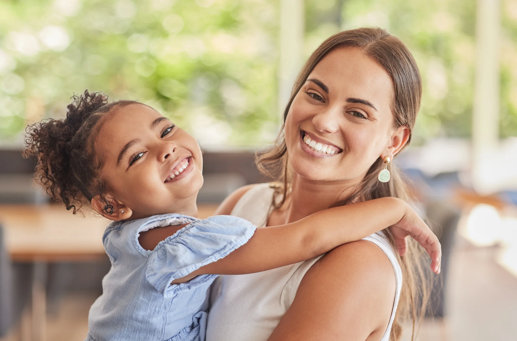 Mother smiling and holding her young daughter