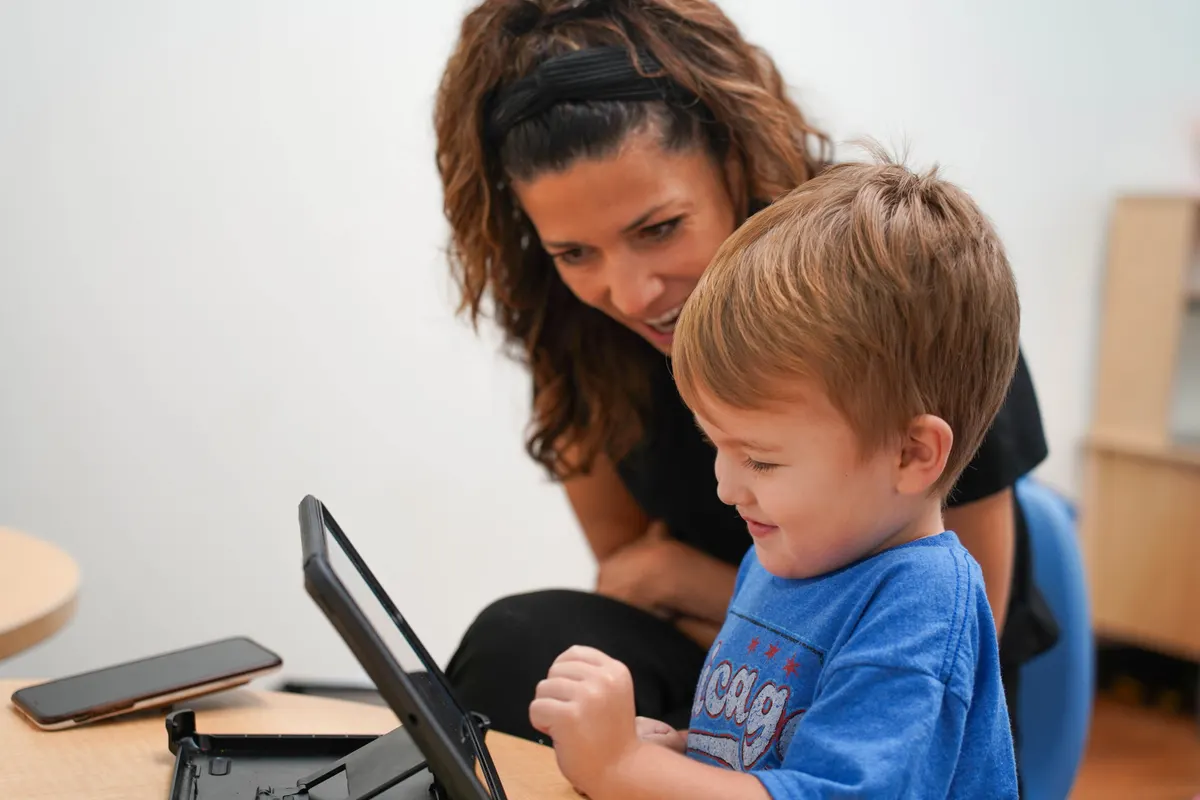 Child and therapist during a technology-assisted ABA session