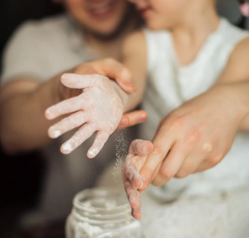 a woman and child are playing with flour together