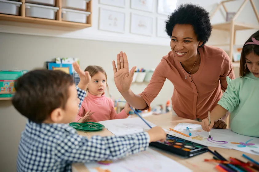 a woman giving a high five to a group of children