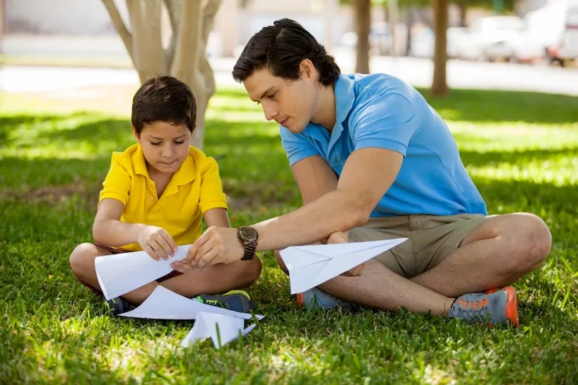 therapist helping child make paper airplanes