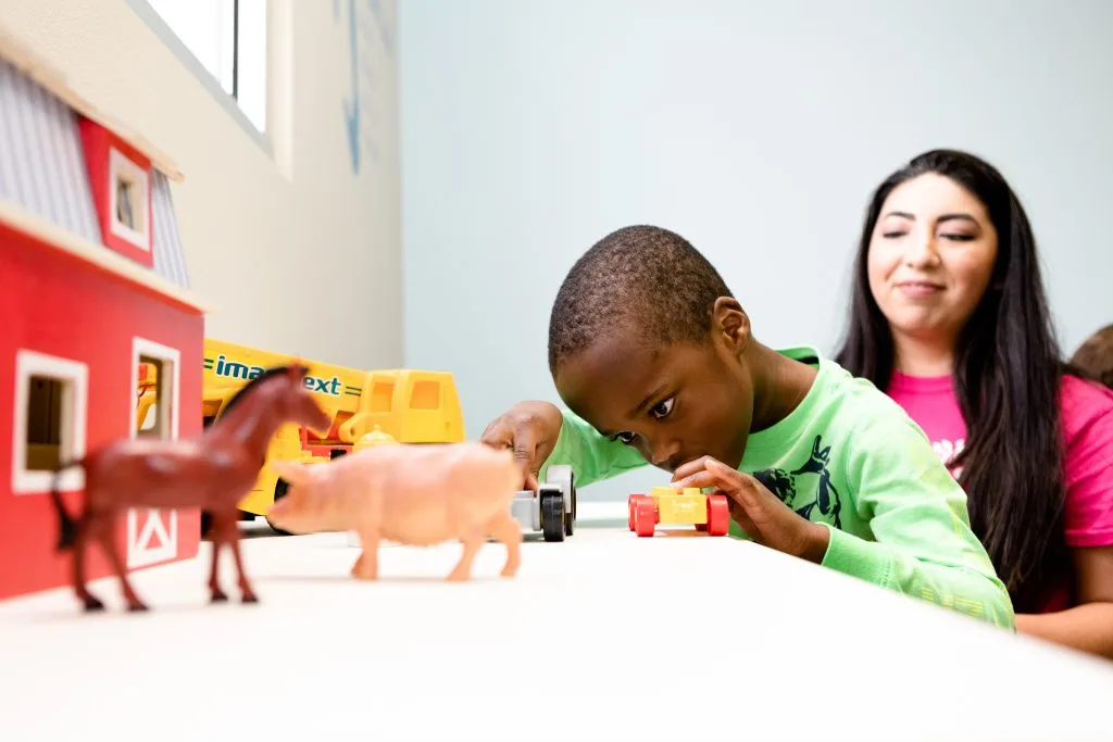 a child playing with a toy truck that says ' ext ' on it