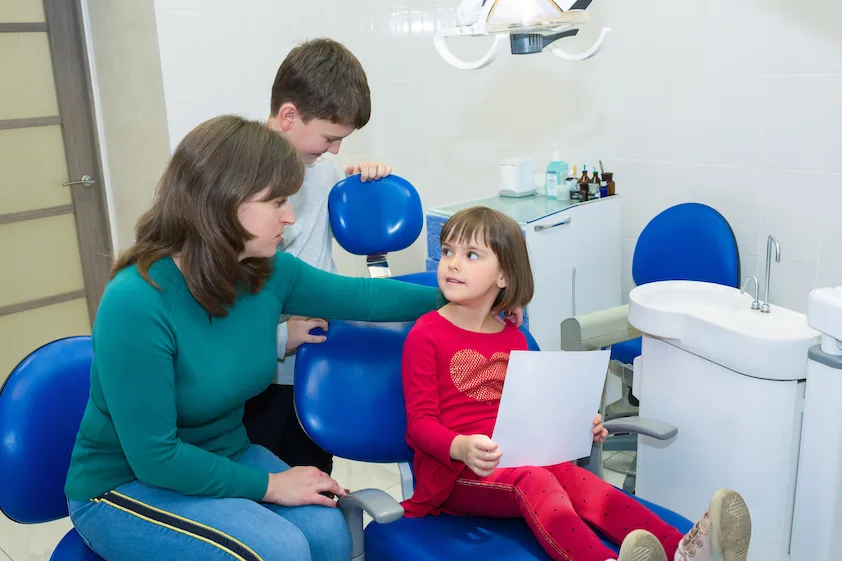 family comforting little girl after a dentist visit