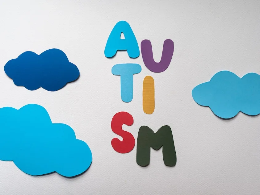 the word autism is surrounded by blue clouds