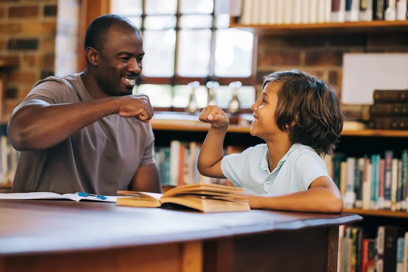 father congratulates son while reading a book