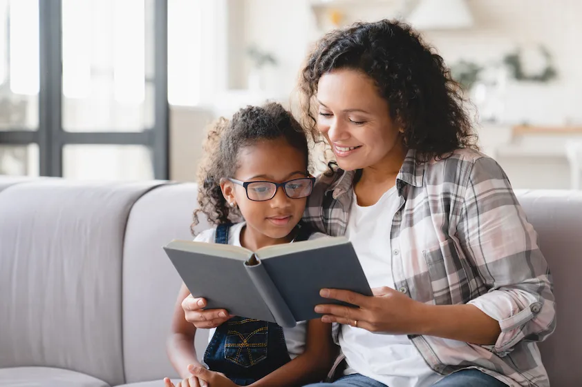 mother and daughter reading a book at home