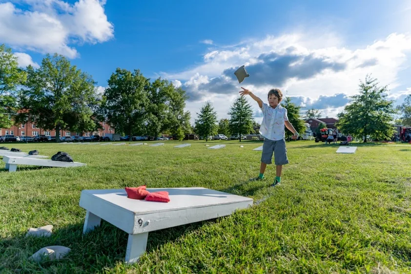 child playing cornhole