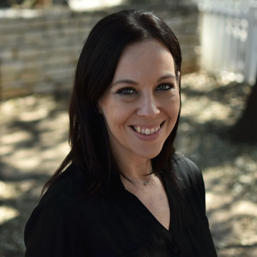 a woman in a black shirt smiles for the camera