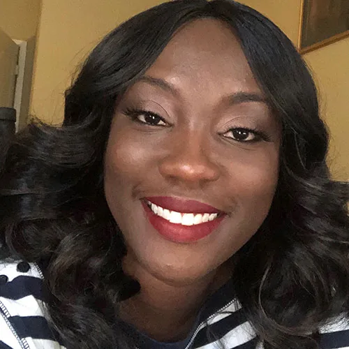 a woman wearing a striped shirt and red lipstick smiles for the camera