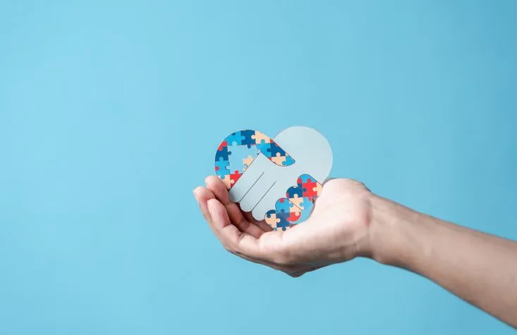 People hand holding jigsaw puzzle, Color puzzle symbol of awareness for autism spectrum disorder family support. Autism World Awareness Day.