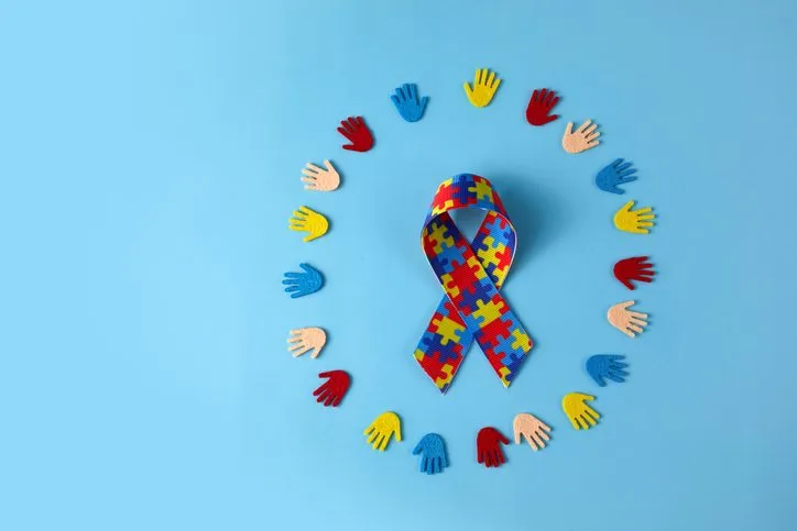 Autism awareness concept with colorful hands on blue background. Top view