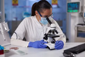 Investigador especializado analiza una muestra genética con un microscopio médico