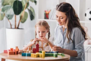 psychologist playing blocks with little child