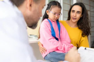 Psychotherapist working with child patient and mother in office