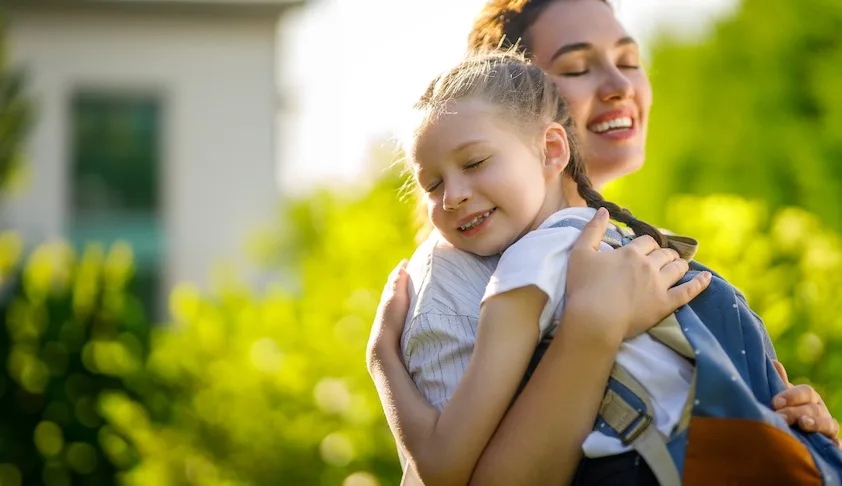 Mother hugging daughter