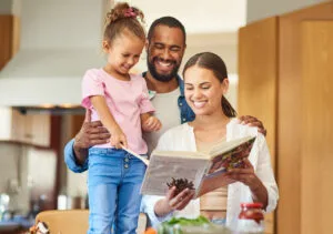 couple and their daughter cooking together in the kitchen at home