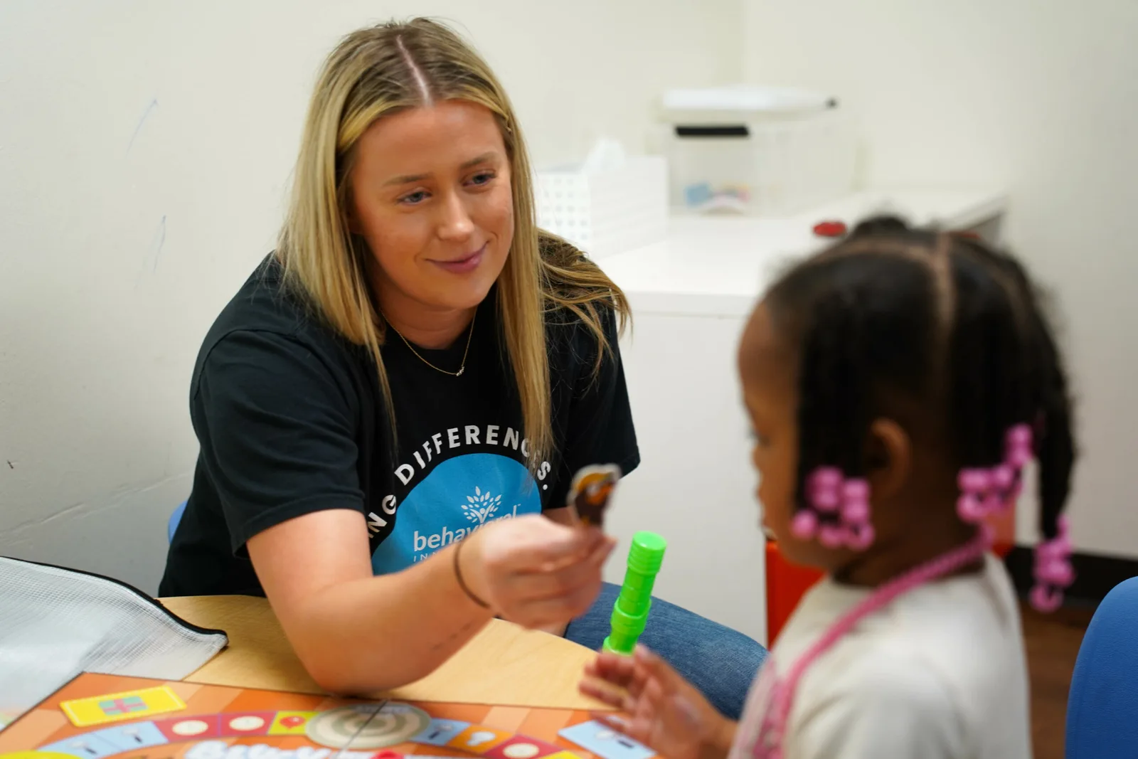a woman wearing a shirt that says " one difference " talks to a little girl