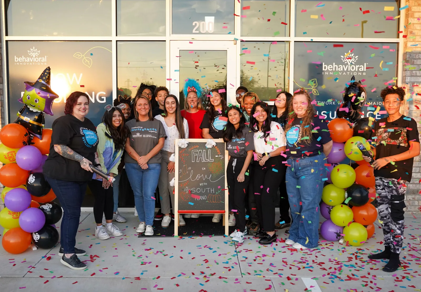 a group of people standing in front of a behavioral initiatives building