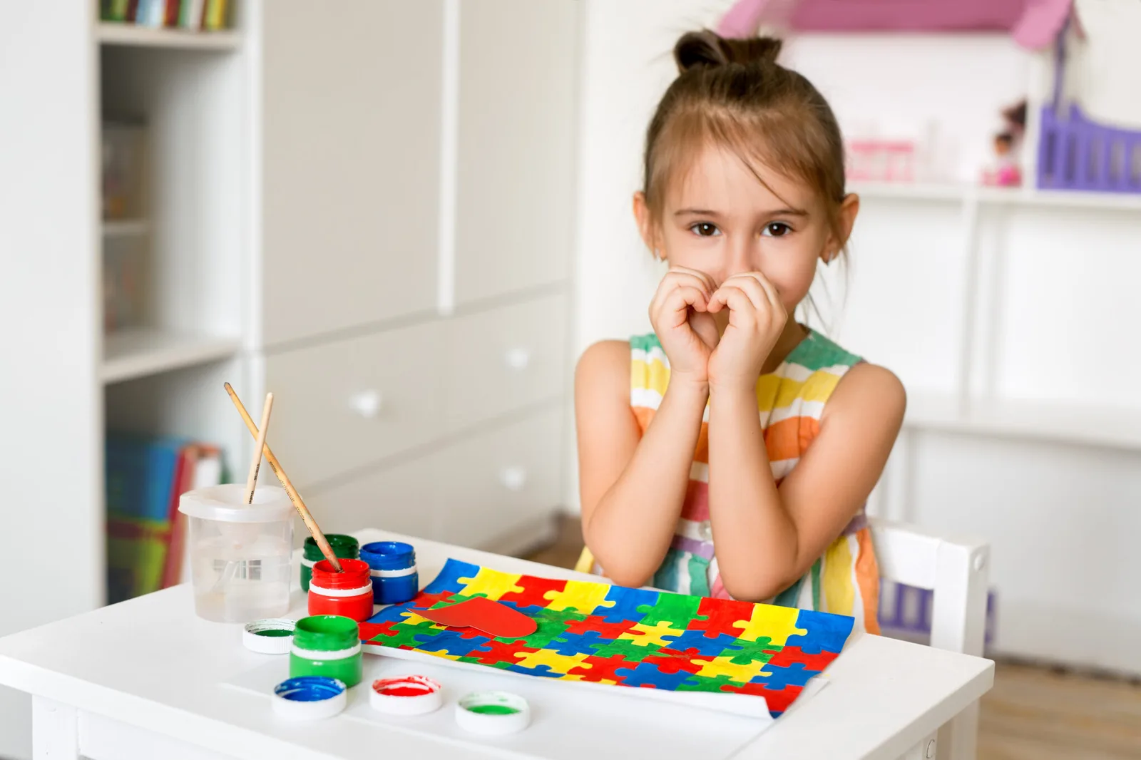 The girl folded her hands in the form of a heart as a sign of support for children with autism