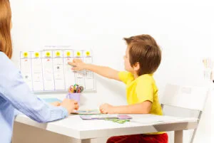 El niño señala las actividades de los días de aprendizaje del calendario