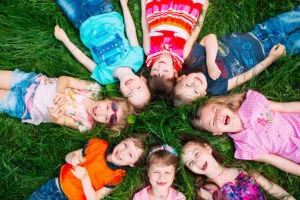 children laying in grass in a circle