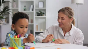 boy coloring with mother at home