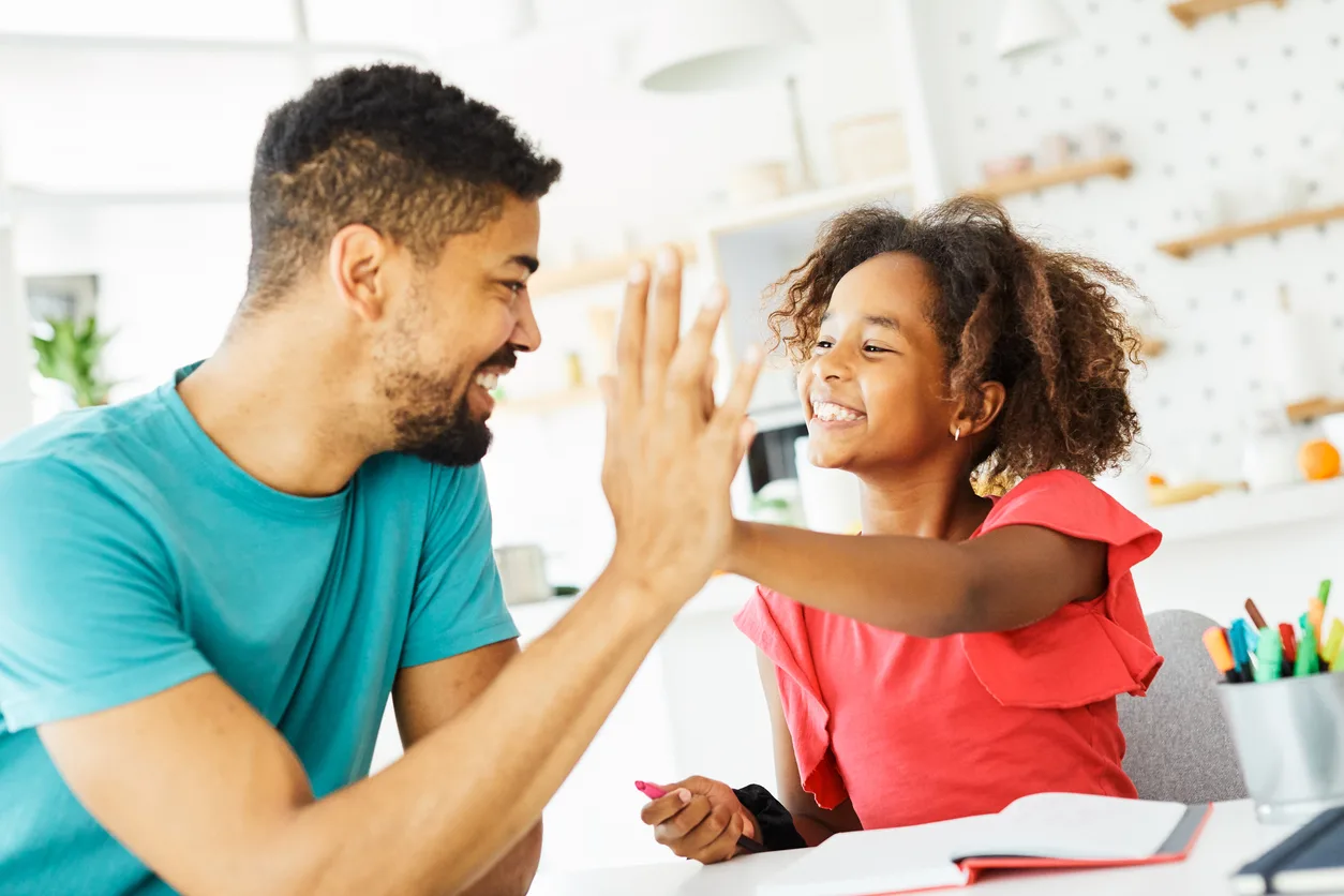 a man and a girl are giving each other a high five