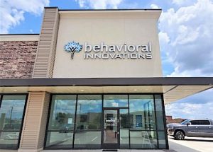 the front of a behavioral innovations building with a car parked in front of it