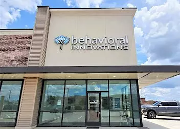 the front of a behavioral innovations building with a car parked in front of it