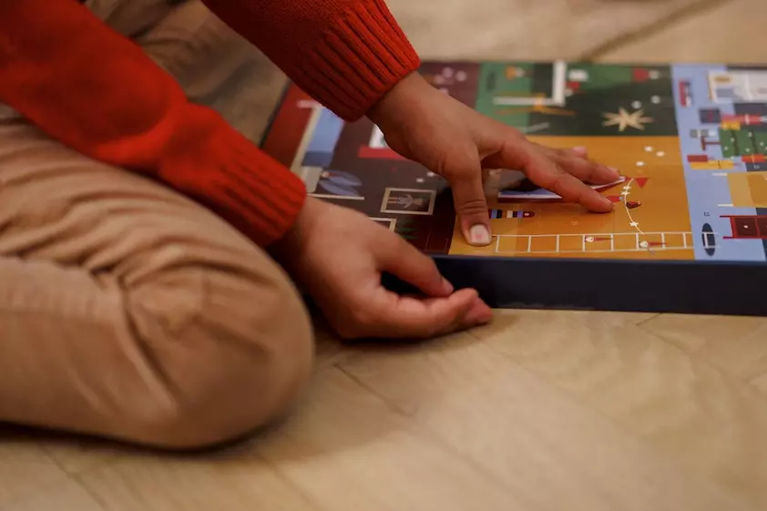 a child is playing with a board game on the floor