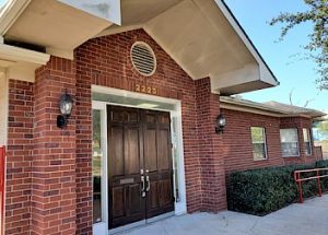 the front door of a brick building with a wooden door