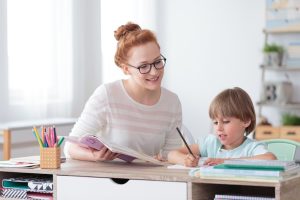 a woman is helping a young boy with his homework