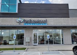 a behavioral innovations building with a car parked in front of it
