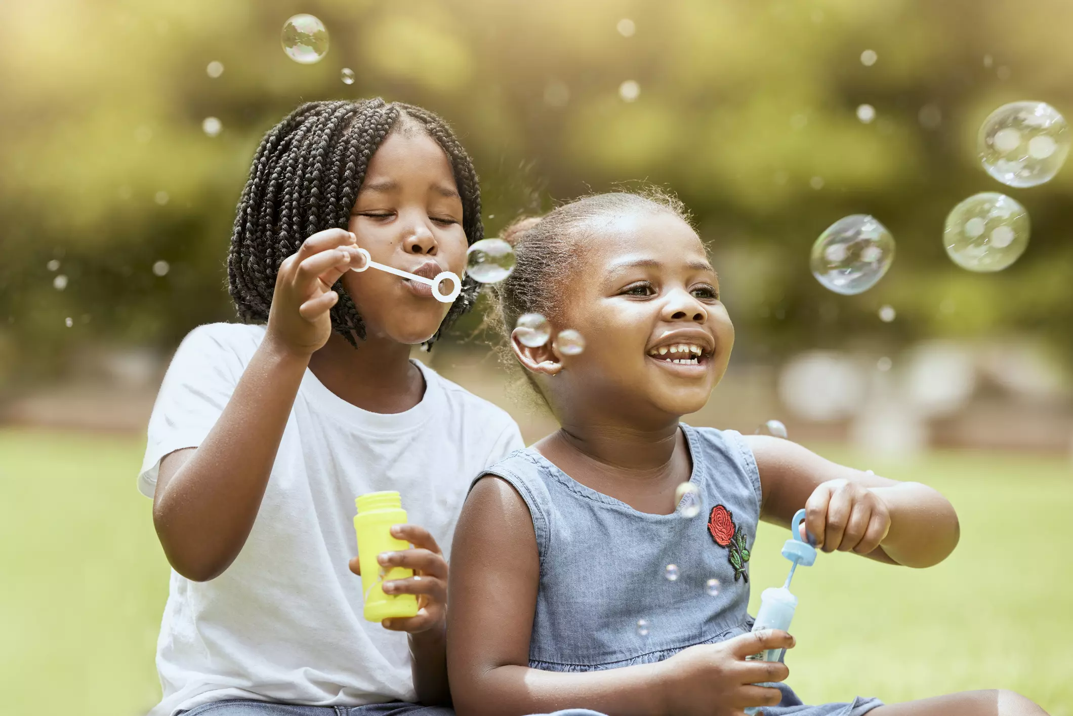 children and blowing bubbles at park