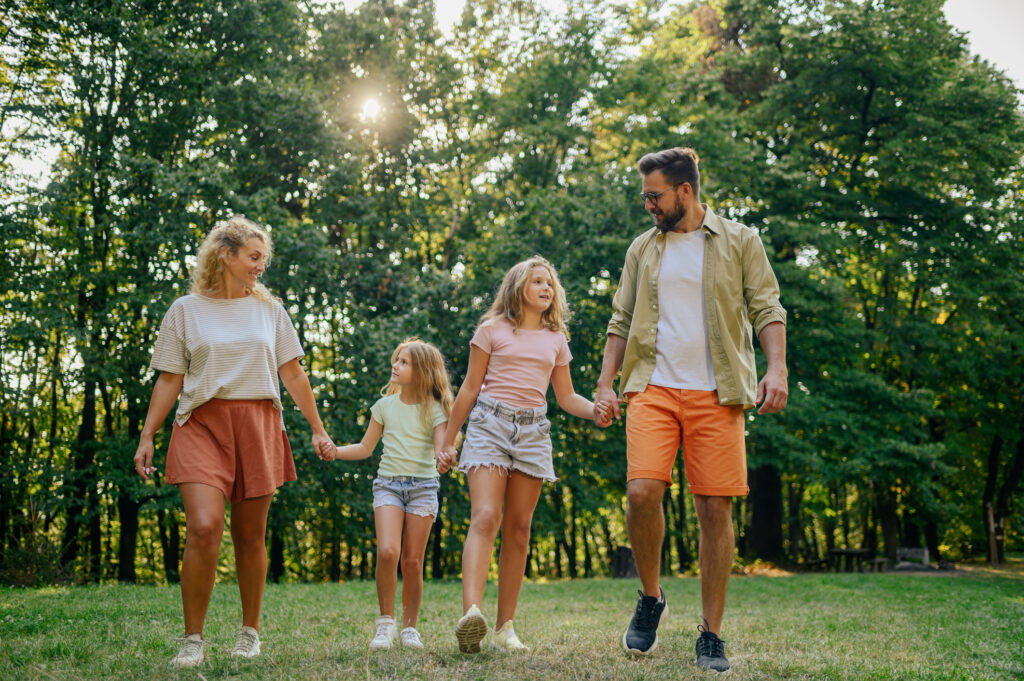 Portrait of a happy family holding hands and taking a walk in nature.
