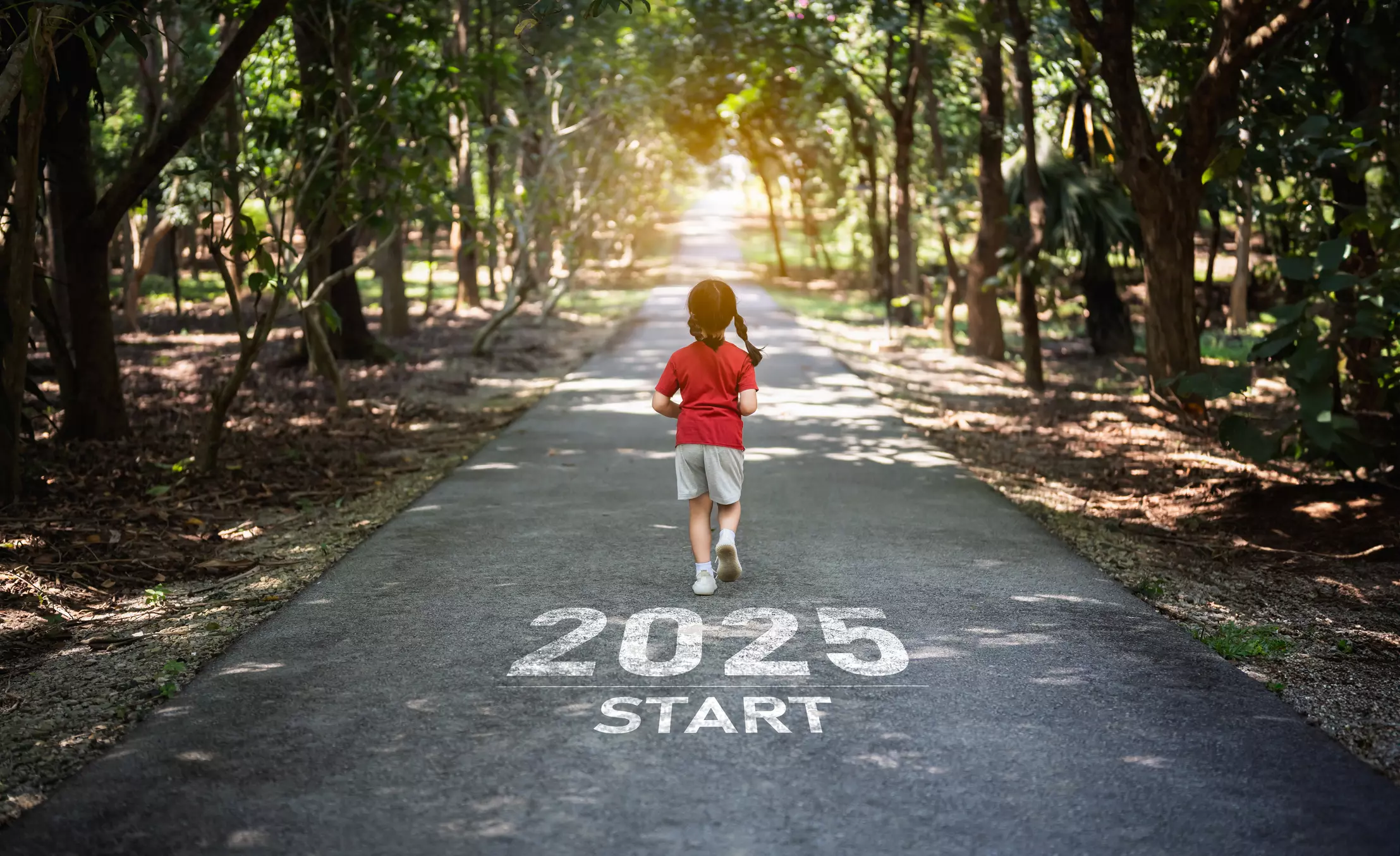 a little girl is running down a road that says 2025 start